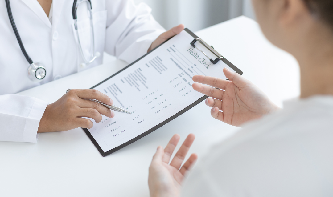 Provider with a clipboard and health checklist talking to a patient