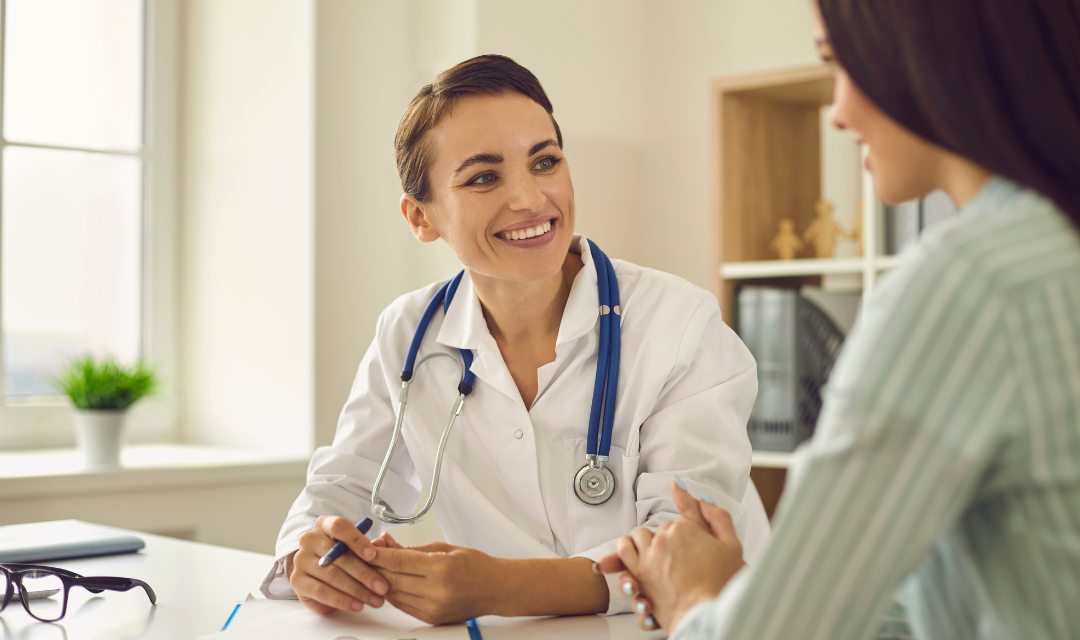 Female provider wearing a stethoscope talking to a young patient